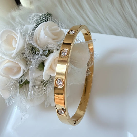 A gold bangle bracelet with rhinestones