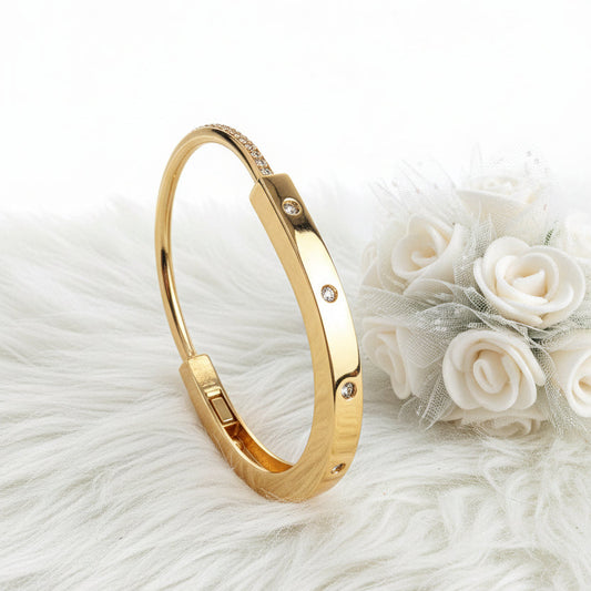 A gold-toned bangle bracelet with small clear rhinestones
